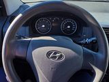a man driving a car on the road with his hand on the steering wheel