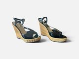 a pair of women ' s blue wedged sandals on a white background