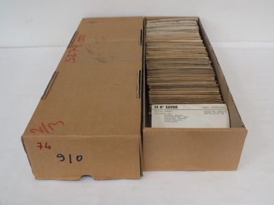 une boîte en carton ouverte, remplie d'une multitude de papiers, posée sur une table blanche