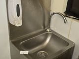 a stainless steel sink with a soap dispenser attached to it