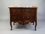 une commode ancienne avec un plateau en marbre posée sur un socle