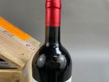 a bottle of red wine sitting next to a wooden box