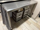 a stainless steel counter with drawers underneath it