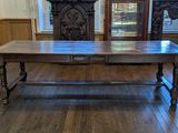 une grande table en bois au milieu d'une pièce
