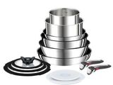 une pile de casseroles et de poêles en acier inoxydable posée sur une table