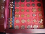 a red case with a bunch of coins inside of it