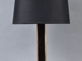 a black and gold table lamp with a black shade