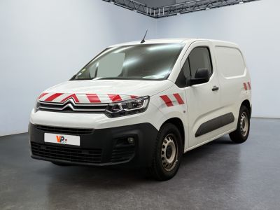 une camionnette Citroën rayée de rouge et de blanc, garée dans une pièce blanche