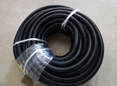 un tuyau noir emballé dans du plastique, posé par terre