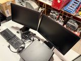 two computer monitors and a keyboard on a desk