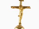 gold crucifix on a pedestal with a flag on top