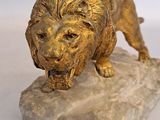 statue of a lion on a rock on a white background