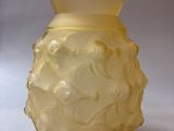 a yellow vase that is sitting on a white surface