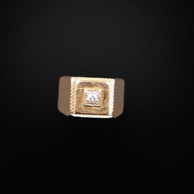 une bague en or avec un diamant carré serti au centre