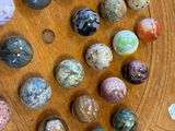 a wooden board with a lot of different colored marbles on it
