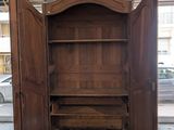 a wooden cabinet with a door open in a room