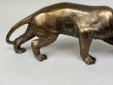 a bronze statue of a lion on a white surface