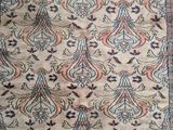 an antique rug with a floral design on a beige ground