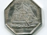 une pièce d'argent sur laquelle est représenté un bateau