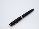 a black and gold pen sitting on top of a white surface
