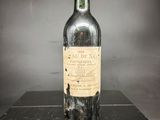 une vieille bouteille de vin posée sur une table noire