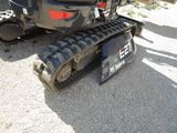 a small black tractor that is parked in the dirt