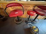 deux tabourets de bar en cuir rouge placés côte à côte devant un mur de briques