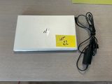 a white laptop computer sitting on a table with a yellow sticker on it