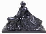 statue d'une femme assise sur un rocher avec un chien