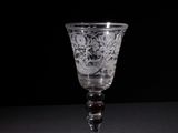 a wine glass sitting on a table with a black background