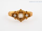 a close up of a gold ring with a white stone in the center