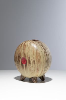 un petit objet en bois sur lequel se trouve un point rouge