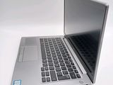 a silver laptop computer sitting on top of a white table