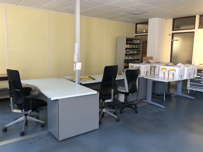 une photo d'une pièce avec un bureau et des chaises