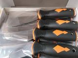 four black and orange knives in a white box on a table