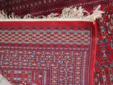 a red rug on the floor next to a rug on the floor