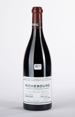 une bouteille de vin posée sur une table blanche