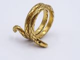 a close up of a gold snake ring on a white surface