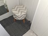 a small stool in the corner of a small room
