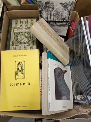 a box full of books and a clock on a table