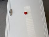 a white cabinet with a red button on it