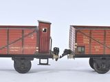 deux petits trains miniatures posés côte à côte sur une surface blanche