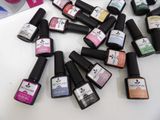 bottles of nail polish sitting on top of a table next to a bottle of nail polish