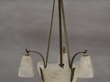 un lustre ancien muni de trois abat-jours en verre suspendu au plafond