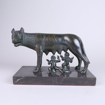 statue en bronze représentant un chien et trois enfants, posée sur un socle en marbre