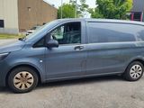La petite camionnette est garée sur le parking, à côté d'autres voitures.
