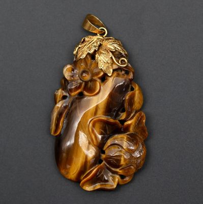une image d'un pendentif en œil-de-tigre orné de feuilles