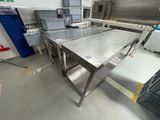 une grande table en acier inoxydable au milieu d'une cuisine