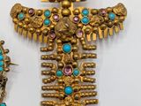 a close up of a gold and turquoise broochle and earrings