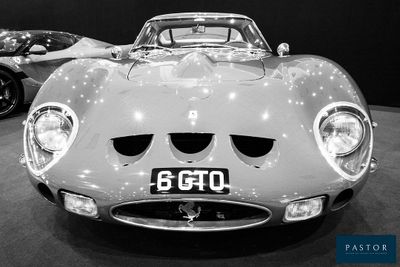photographie en noir et blanc d'une voiture de sport exposée dans un showroom
